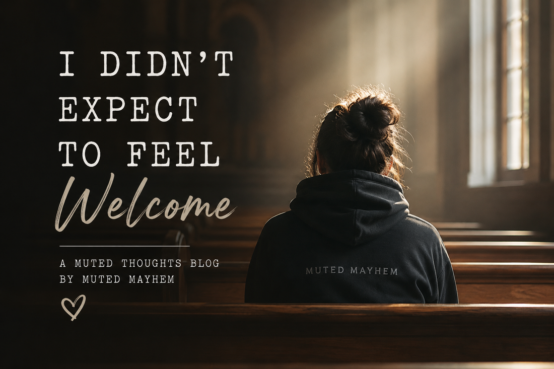 Person sitting alone in a church wearing a Muted Mayhem hoodie, reflecting on belonging, acceptance and finding a place to feel welcome.