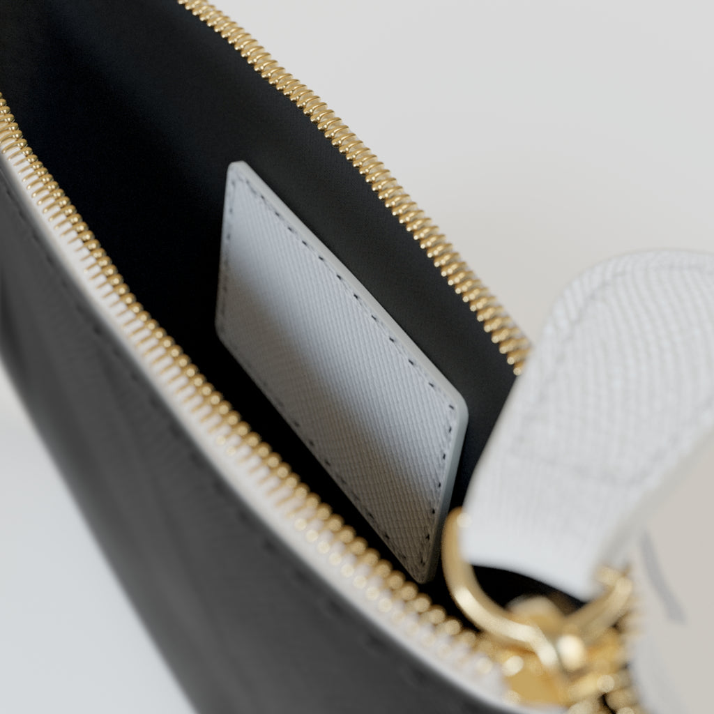 Close-up of a black pouch with pink text and gold zipper on a white background