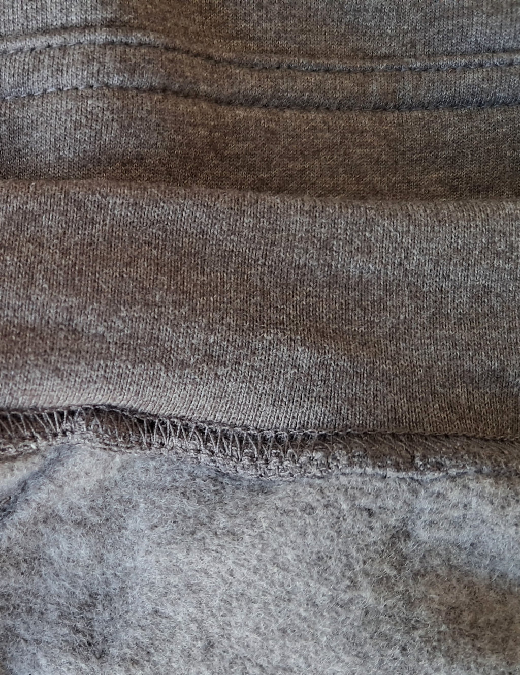 Close-up of gray fabric with visible stitching promoting mental health and neurodivergence awareness by muted mayhem 