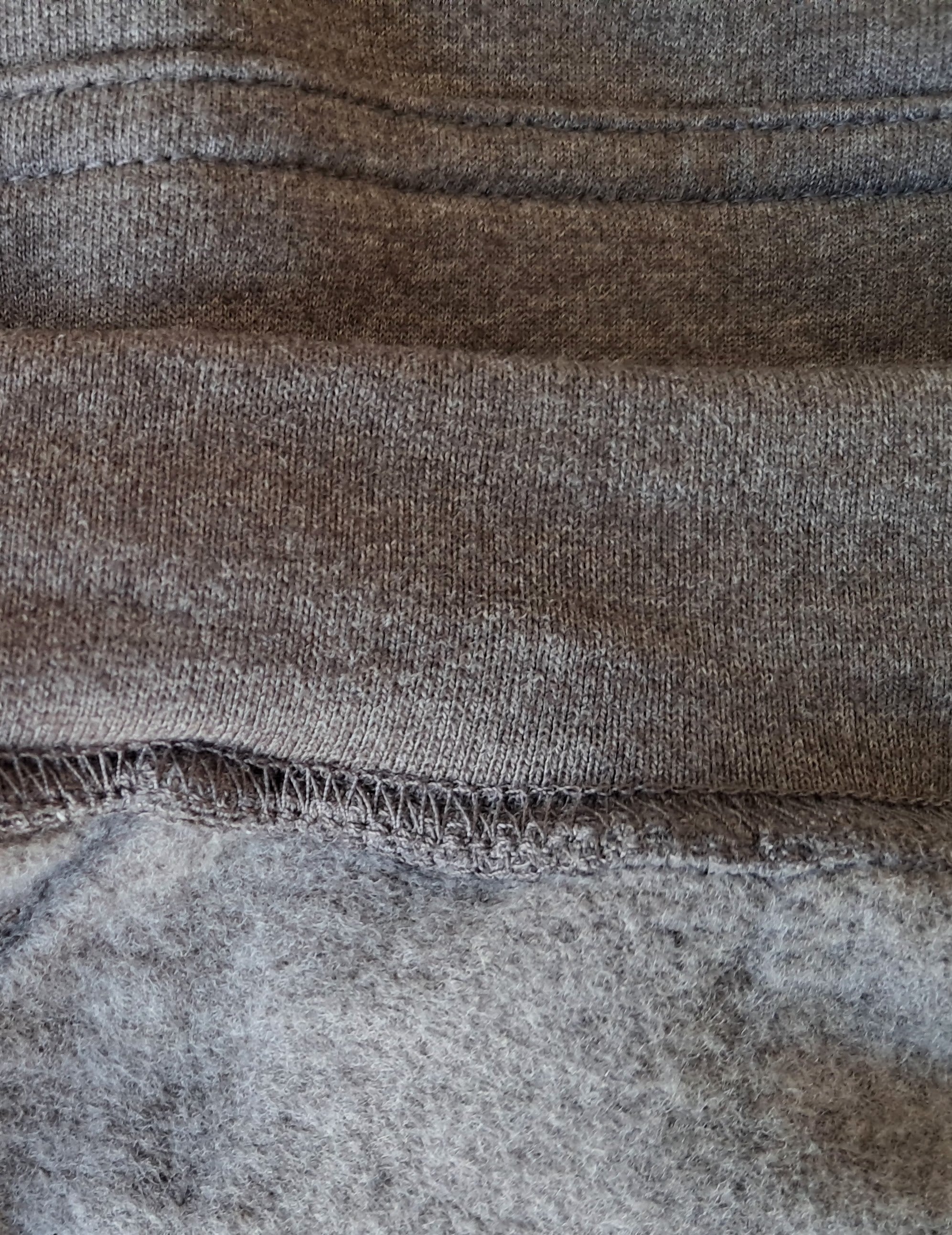 Close-up of gray fabric with visible stitching promoting mental health and neurodivergence awareness by muted mayhem 