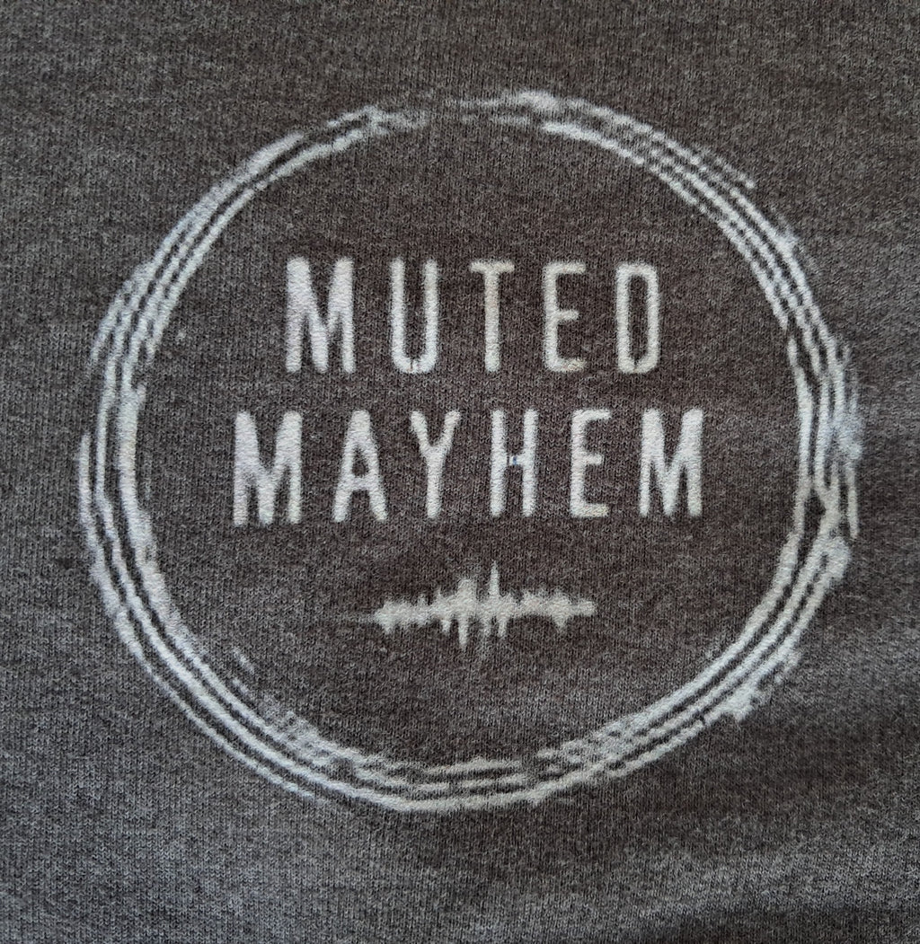 Text 'Muted Mayhem' on a textured surface with sound wave graphic promoting mental health and neurodivergence awareness by muted mayhem 