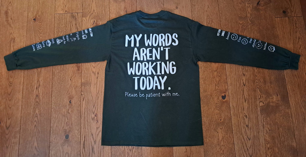 A dark charcoal long-sleeve t-shirt with white text on the back reading 'MY WORDS AREN'T WORKING TODAY. Please be patient with me.