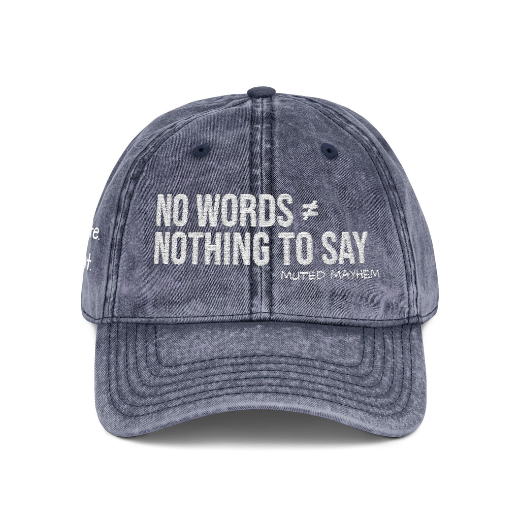 A washed dark gray baseball cap with white embroidered text reading 'NO WORDS ≠ NOTHING TO SAY' and smaller text 'MUTED MAYHEM' below, shown on a plain white background.