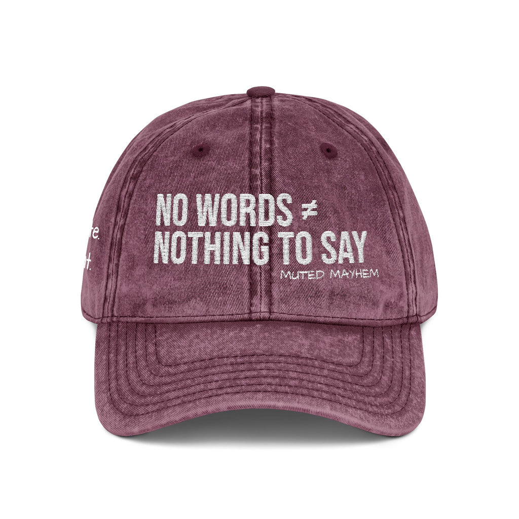 A washed mauve-purple baseball cap with white embroidered text reading 'NO WORDS ≠ NOTHING TO SAY' and smaller 'MUTED MAYHEM' branding, shown on a clean white background.